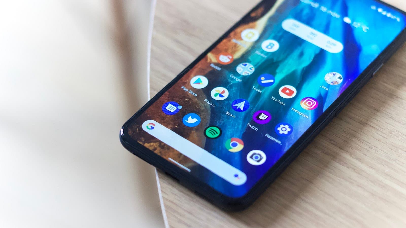 Android telefon na stolu, sa prikazanim ikonicama aplikacija