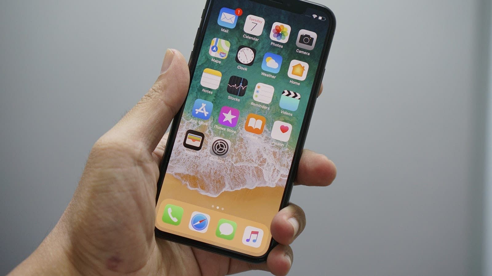 iPhone u ruci, sa otključanim početnim ekranom