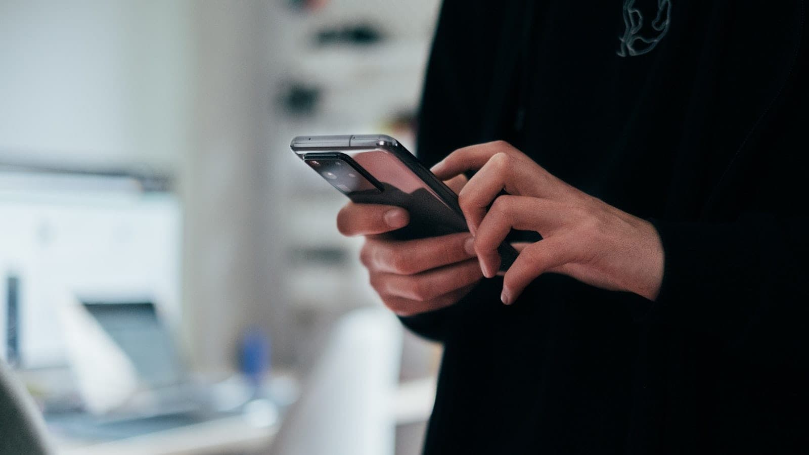 Ruke drže telefon i kucaju poruku