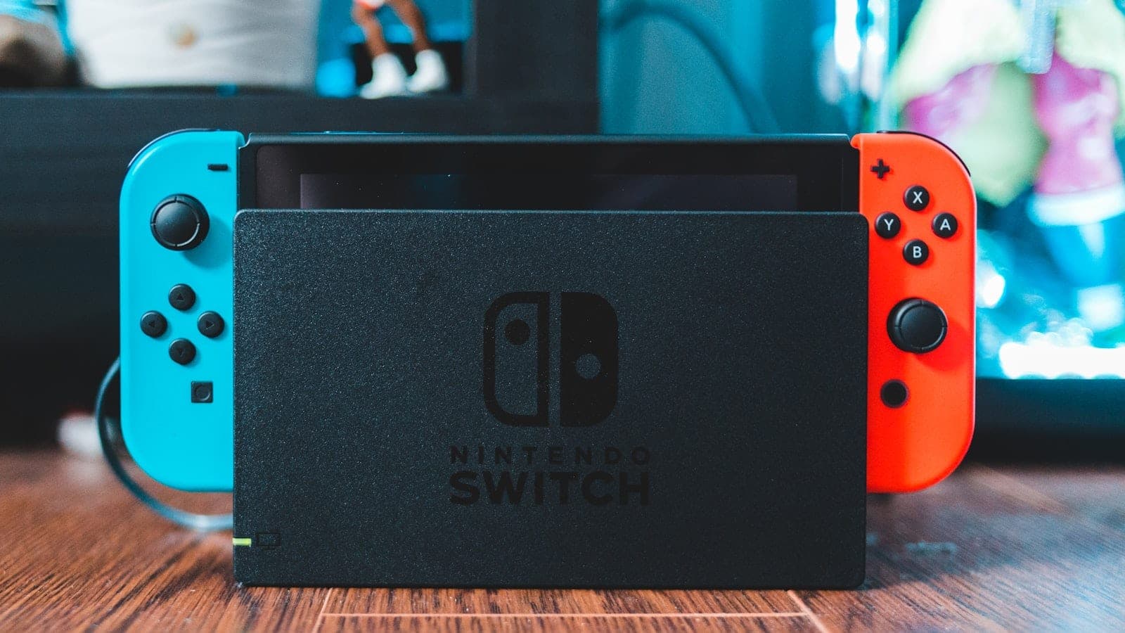 Nintendo Switch u doku, sa crvenim i plavim Joy-Con kontrolerima