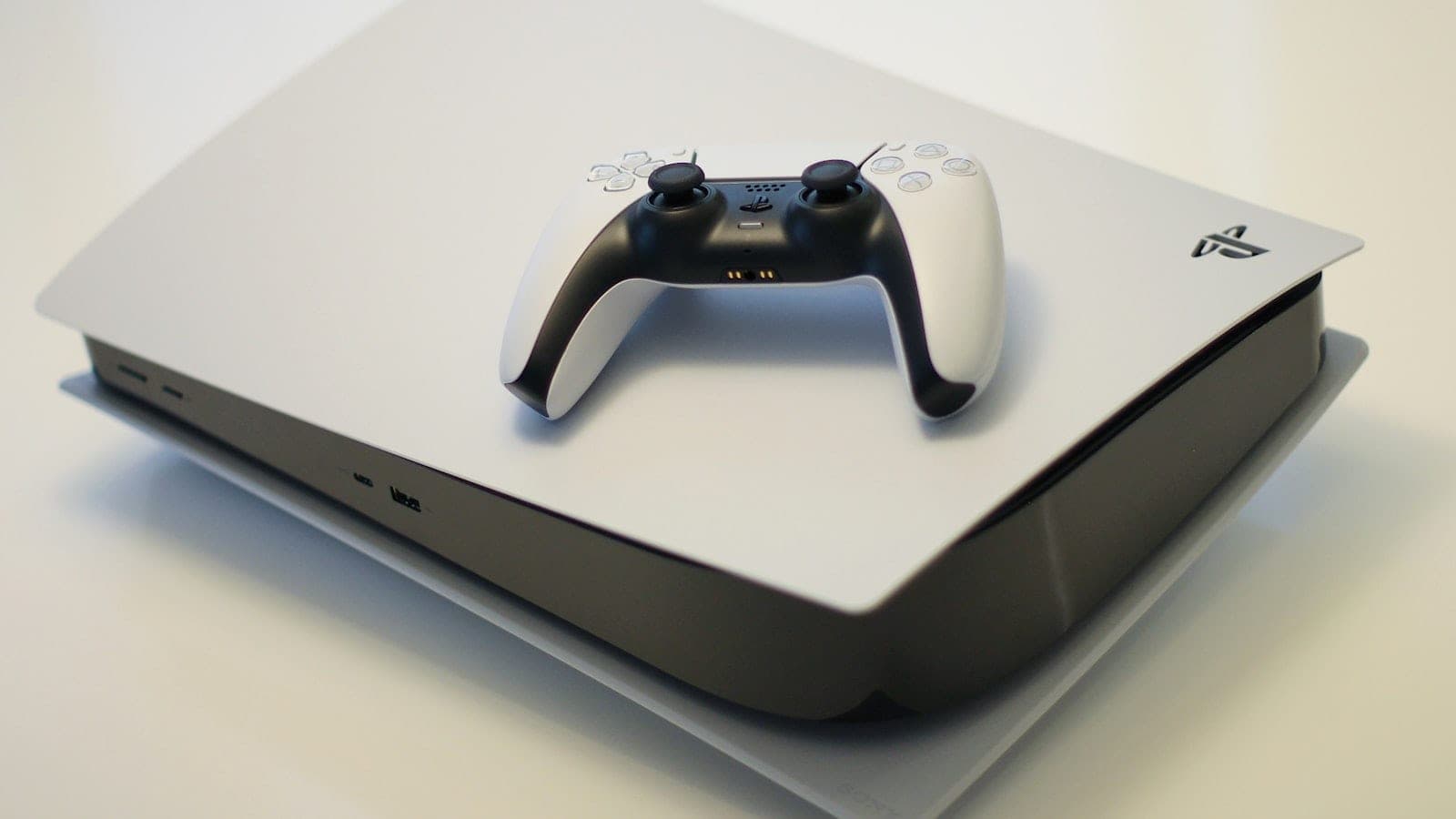 PlayStation 5 položen vodoravno, sa DualSense kontrolerom