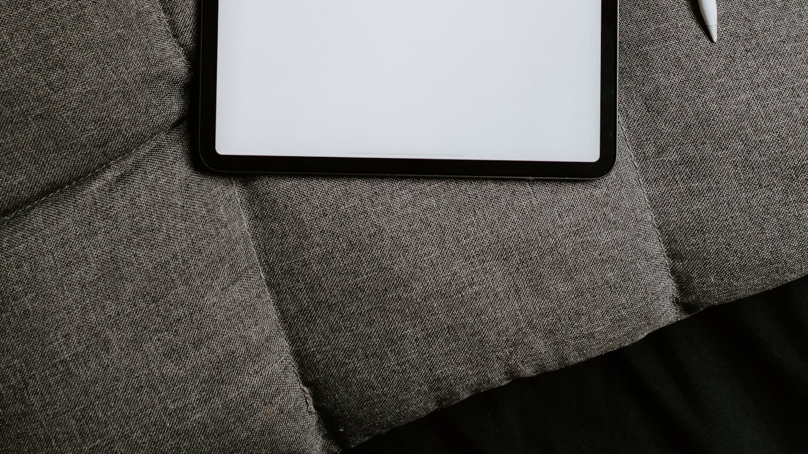 Tablet sa olovkom položen na tkaninu