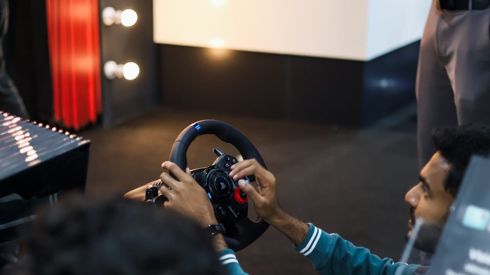 Vozač za sim racing volanom ispred ekrana