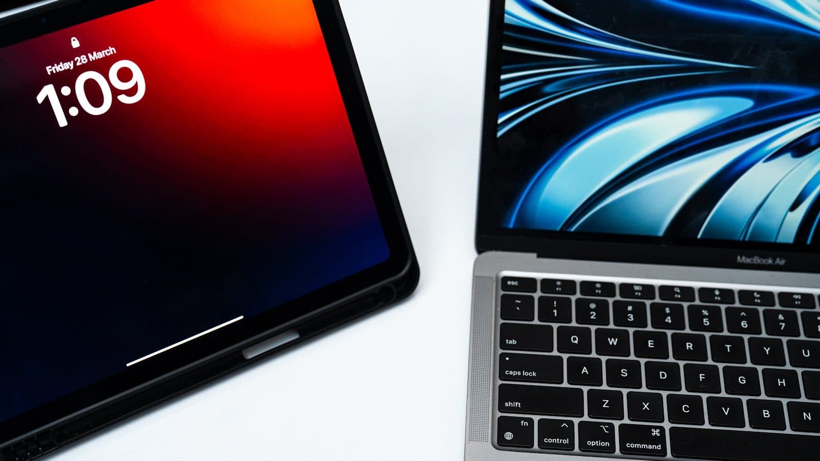 Tablet i laptop jedan pored drugog na beloj podlozi